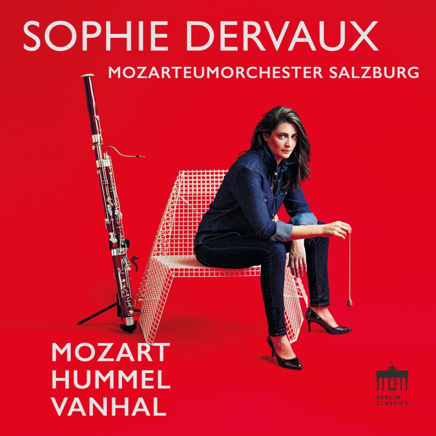 Release-Cover „Mozart – Hummel – Vanhal“ von Fagottistin Sophie Dervaux mit dem Mozarteumorchester Salzburg. Sophie Dervaux sitzt auf einem weißen Drahtstuhl neben stehendem Fagott vor leuchtend rotem Hintergrund; frontale Studioansicht, starke Kontraste und selbstbewusste Pose.