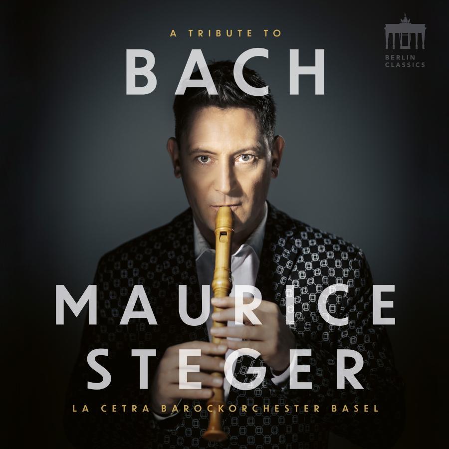 Release-Cover „A Tribute to Bach“ von Blockflötist Maurice Steger mit La Cetra Barockorchester Basel. Dunkles Porträt mit Blockflöte vor dem Gesicht und großer weißer Typografie; frontale Nahaufnahme, dramatisches Licht und konzentrierte Musikerwirkung.
