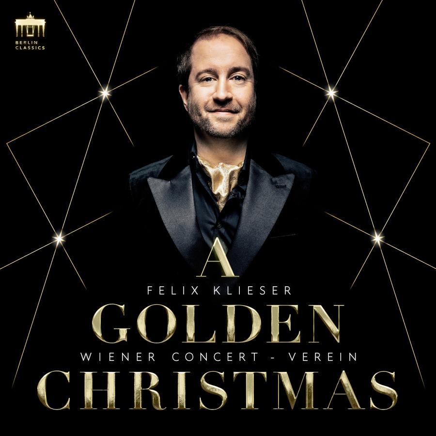 Release-Cover „A Golden Christmas“ von Hornist Felix Klieser mit Wiener Concert-Verein. Dunkles Porträt im schwarzen Anzug vor sternförmigen Lichtlinien, überlagert von goldener Typografie; festliche, kontrastreiche und elegante Weihnachtsstimmung.