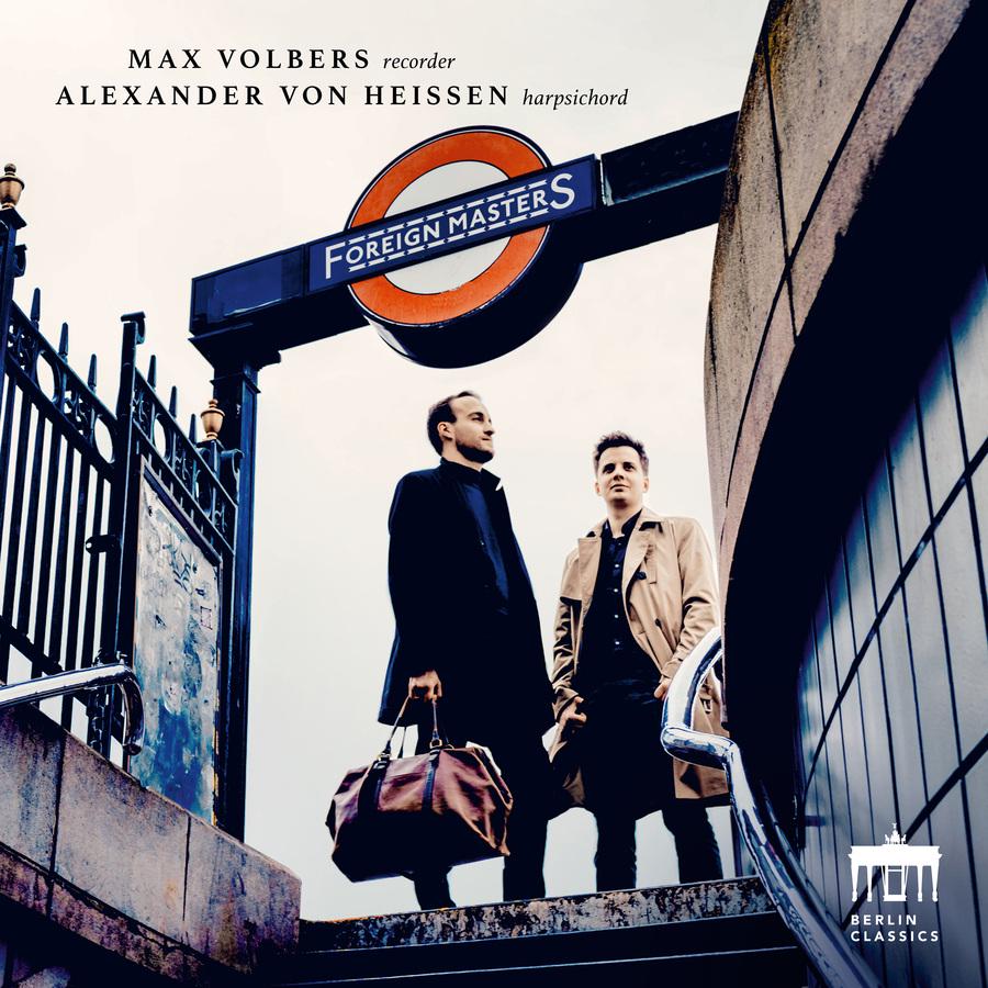Release-Cover „Foreign Masters“ mit Max Volbers an der Blockflöte und Alexander von Heißen am Cembalo. Zwei Musiker stehen am Eingang einer U-Bahn-Station mit Taschen, aufgenommen aus leichter Untersicht; kühle Stadtfarben, grafisches Schildmotiv und urbane Perspektive.