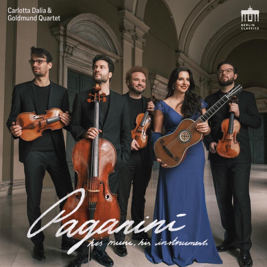 Release-Cover „Paganini - His music, his instruments“ von Gitarristin Carlotta Dalia und Streichquartett Goldmund Quartet. Alle Musiker:innen sind mit ganzem Körper abgebildet und halten ihre Instrumente in den Händen. Im Hintrgrund ist der Flur eines alten Gebäudes zu sehen, die Gesichter sind beleuchtet und fröhlich. Der Album Titel ist handschriftlich, sehr geschwungen unten mittig abgedruckt.