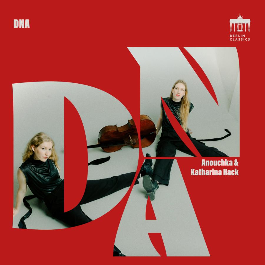 Release-Cover DNA von Anouchka und Katharina Hack. Knallroter Hintergrund mit großen, über das gesamte Bild ausgeschnittenen Buchstaben DNA. In zweiter Ebene sitzen die Künstlerinnen breitbeinig auf einem hellgrauen Boden, zwischen ihnen liegt ein Cello. Sie blicken freundlich in die Kamera.