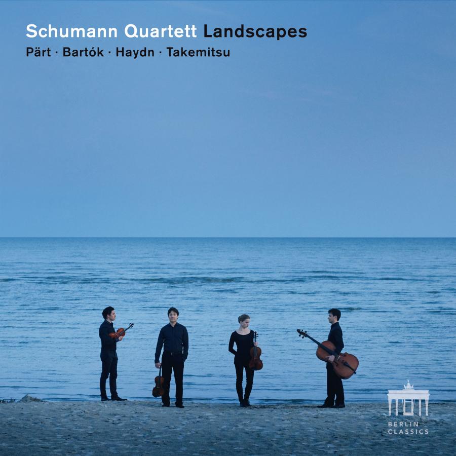 Release-Cover „Landscapes“ des Schumann Quartetts mit Werken von Pärt, Bartók, Haydn und Takemitsu. Vier Musiker:innen aus entfernter Perspektive mit Streichinstrumenten stehen am Strand vor blauem Meer und Himmel; kühle Blautöne, große Distanz und ruhige Naturatmosphäre.