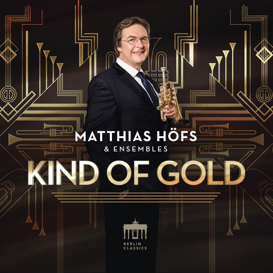 Release-Cover „Kind of Gold“ von Trompeter Matthias Höfs & Ensembles. Matthias Höfs steht mit Trompete vor schwarzem Hintergrund mit goldenen Art-déco-Linien; warme Goldtöne, frontale Pose und elegante, festliche Wirkung.