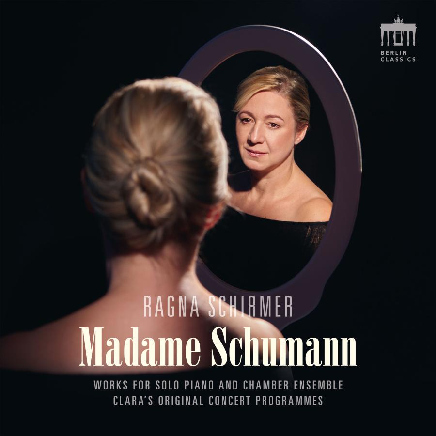 Release-Cover „Madame Schumann“ von Pianistin Ragna Schirmer. Dunkles Porträt vor einem Spiegel, ihr Gesicht ist als Spiegelbild sichtbar; schwarze Umgebung, warmes Porträtlicht und intime, theatralische Komposition.