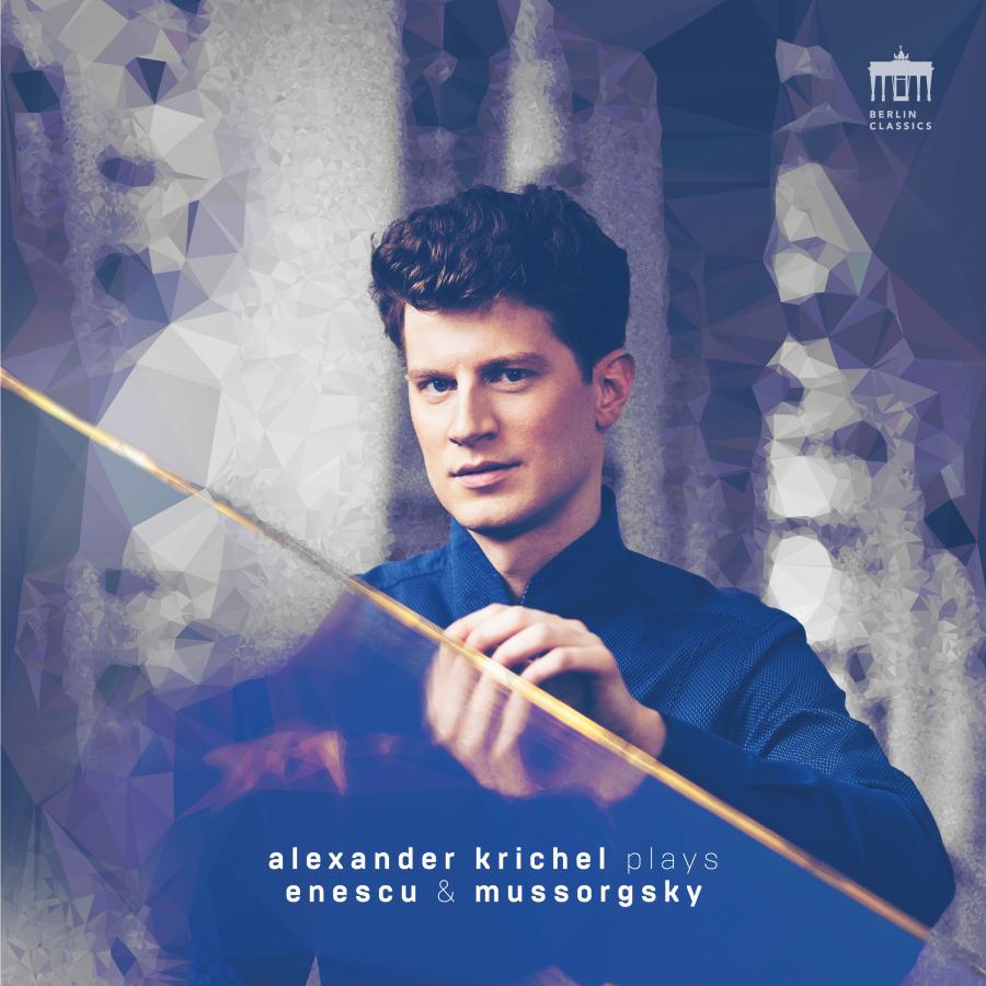 Release-Cover „Enescu & Mussorgsky“ von Pianist Alexander Krichel. Porträt vor kristallartig verfremdetem Hintergrund, ein dünner goldener Stab kreuzt das Bild; kühle Blau- und Violetttöne, frontale Perspektive und moderne, grafische Wirkung.
